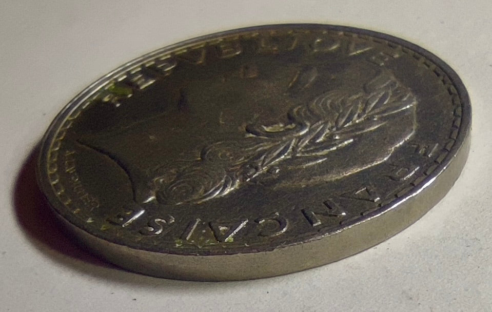 Vue oblique de la 5 francs Lavrillier 1933 et de sa tranche lisse.