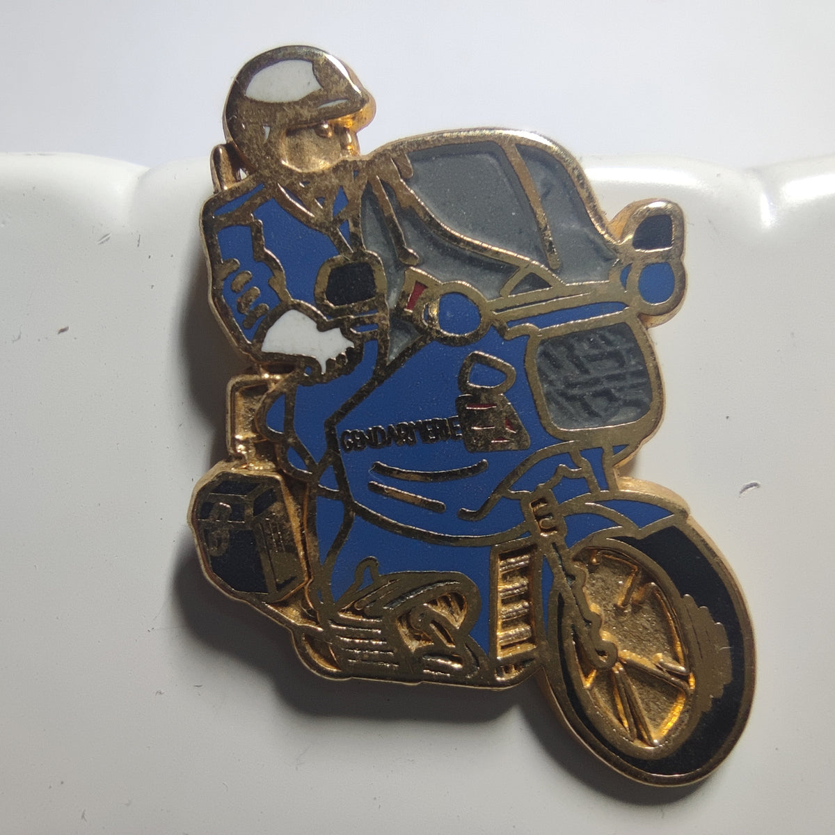 Pin’s Motocycliste de gendarmerie sur moto bleue, version dorée, vers 1990